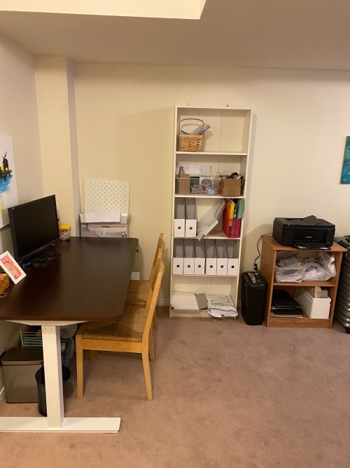 home office space with bookshelf, printer and shredder in the basement living space