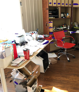 paper, boxes and things are all over and under the desk.