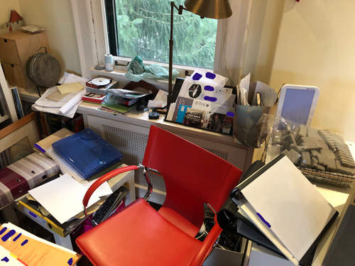a red chair surrounded by various items