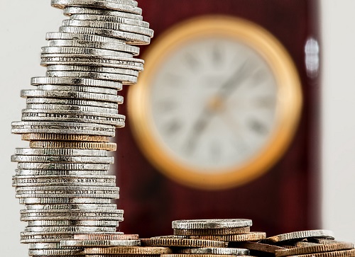 Stacked-coin-with-clock-in-background-500px