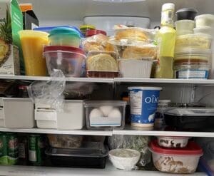 refrigerator filled with groceries and plastic containers