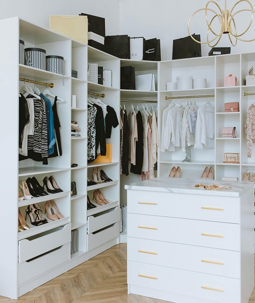 White closet with clothes, shoes and accessories nicely displayed 
