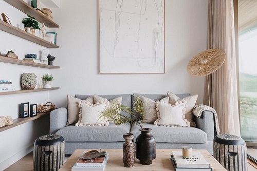 A comfortable living room with simple décor including books, pillows, and other small items