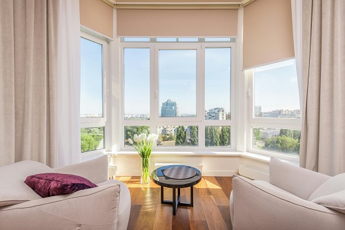 2 seats in the living space facing a large window 
with a natural, bright view of the blue sky an open space.